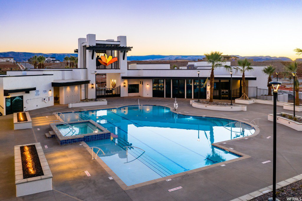 Pool at dusk featuring a patio