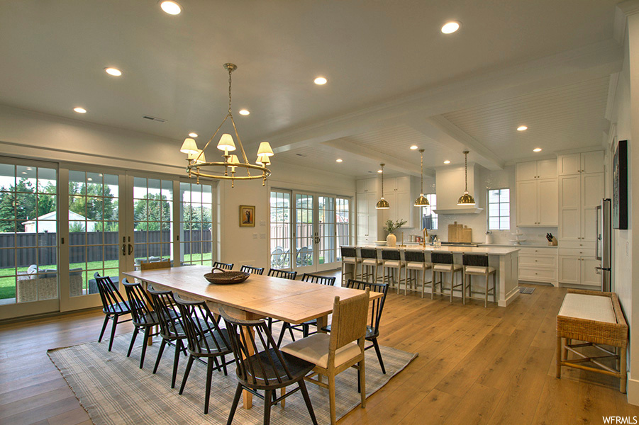 Dining area featuring beamed ceiling, light hardwood floors, and french doors
