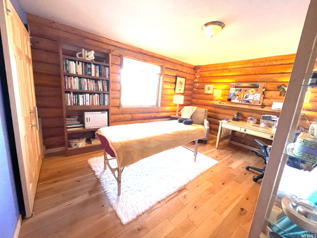 Office space with log walls and light hardwood floors