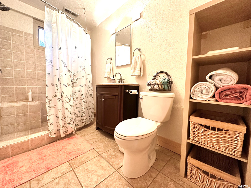 Bathroom featuring light tile flooring, mirror, and vanity