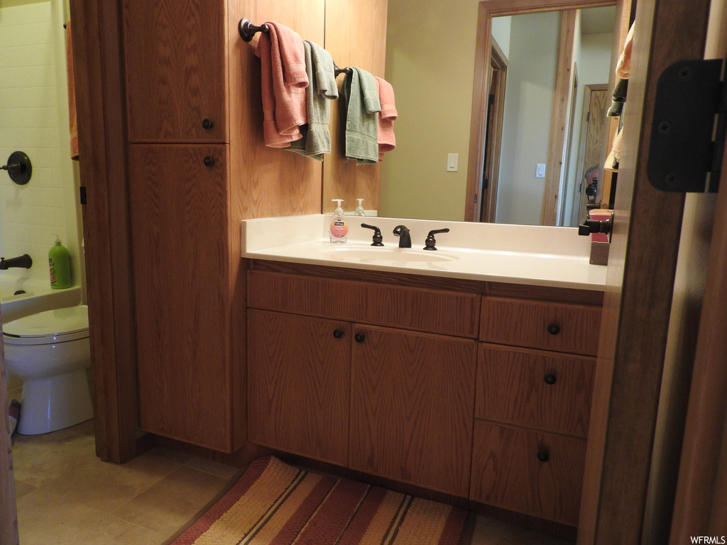 Full bathroom featuring tile flooring, tiled shower / bath, mirror, and vanity