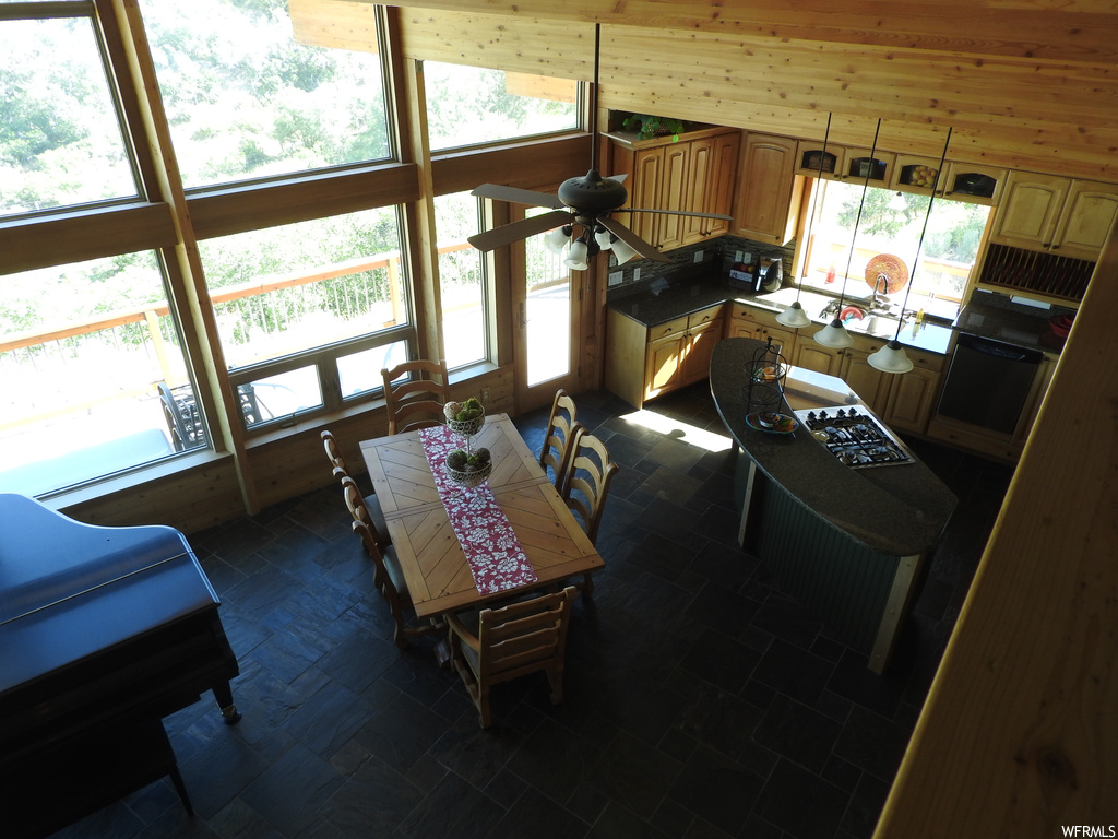 Living room with wood walls, plenty of natural light, and dark tile flooring