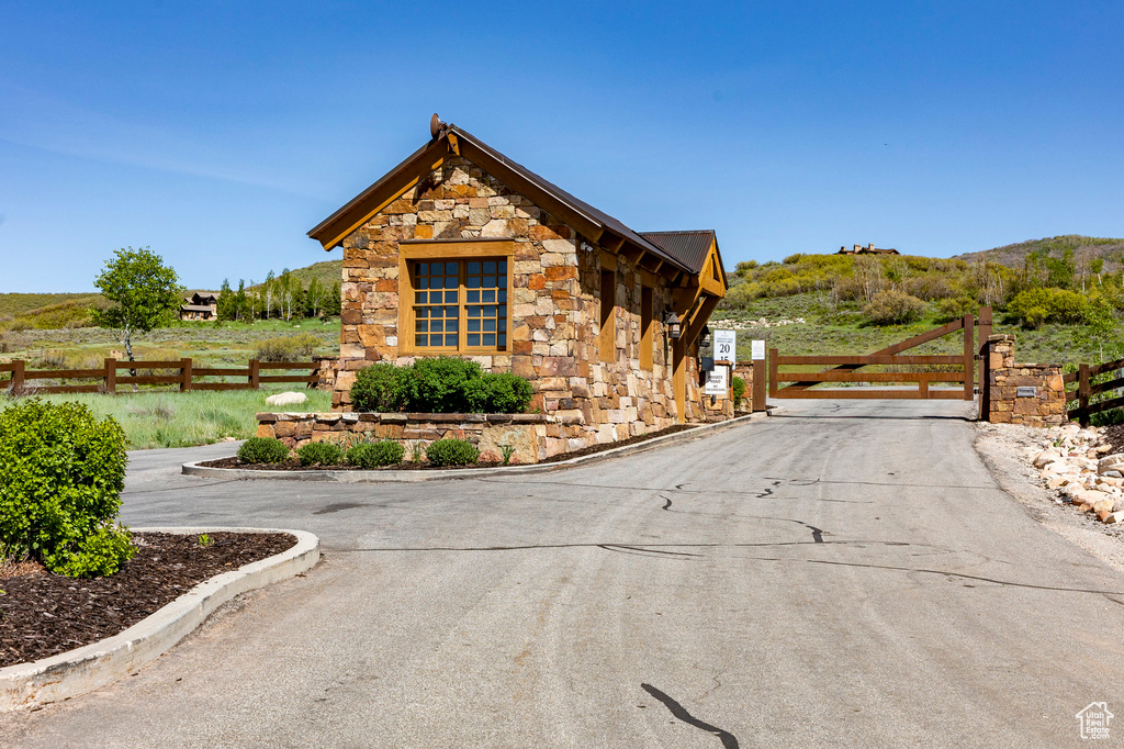 View of front of property with a gate and stone siding