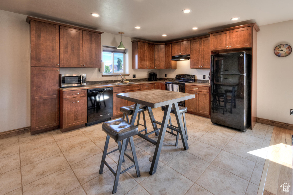 Kitchen featuring black appliances, hanging light fixtures, light tile patterned flooring, and sink