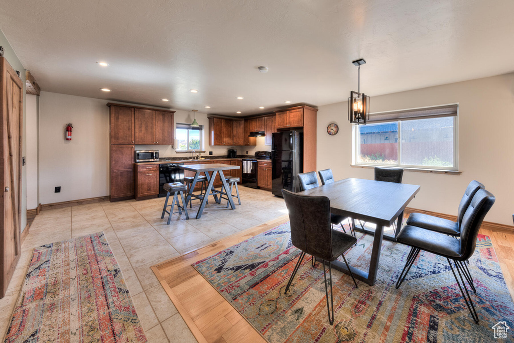 Dining space featuring an inviting chandelier, light tile patterned floors, and sink