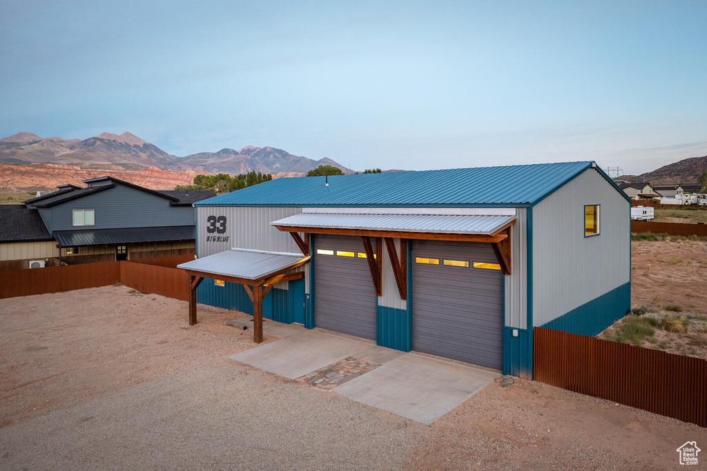 View of front of property with an outbuilding, a garage, and a mountain view