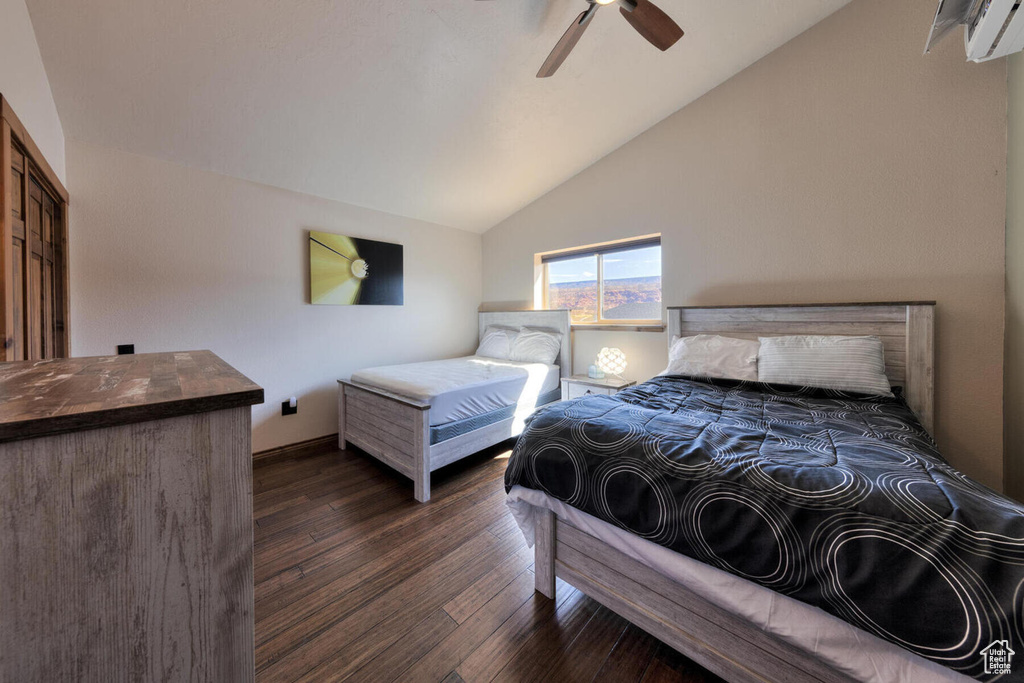 Bedroom with ceiling fan, lofted ceiling, and dark wood-type flooring