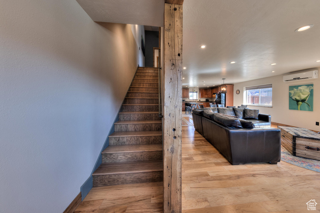 Stairs featuring an AC wall unit and wood-type flooring