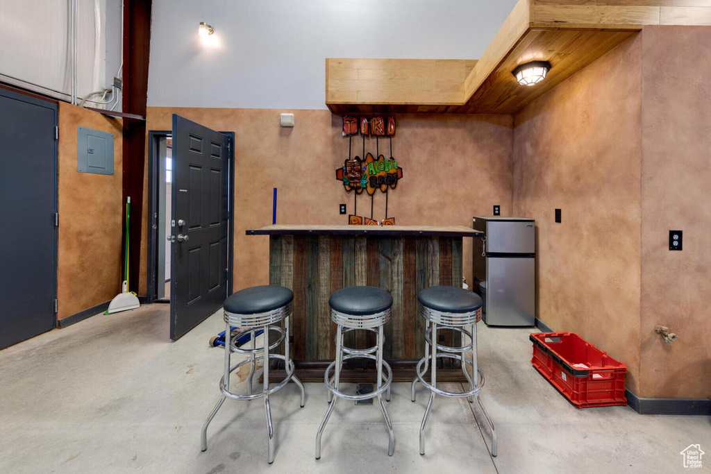 Bar with stainless steel refrigerator and concrete floors