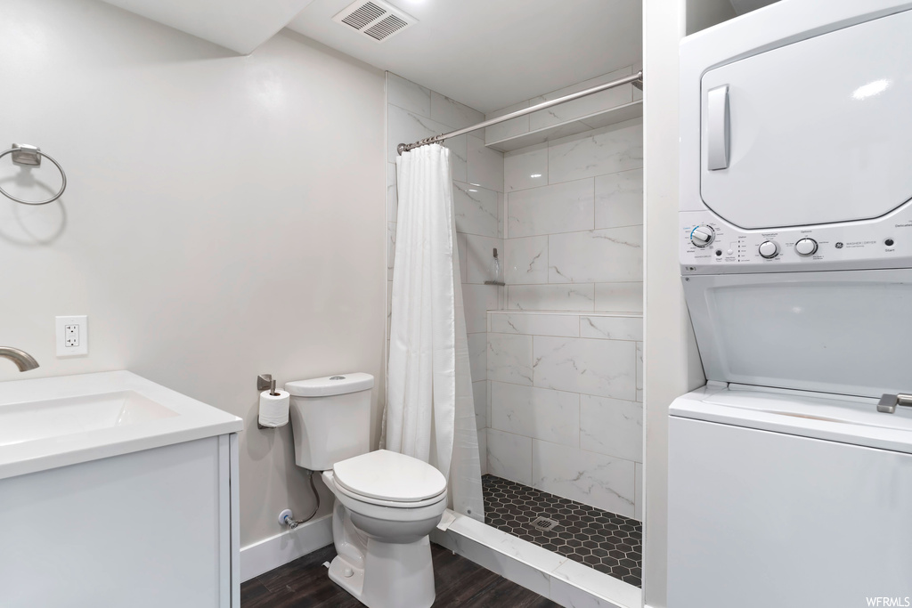 Bathroom featuring washer / dryer, hardwood floors, a shower with curtain, and vanity