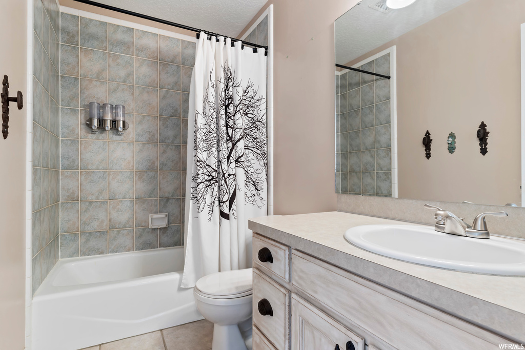Full bathroom featuring vanity, tile flooring, mirror, and shower / tub combo