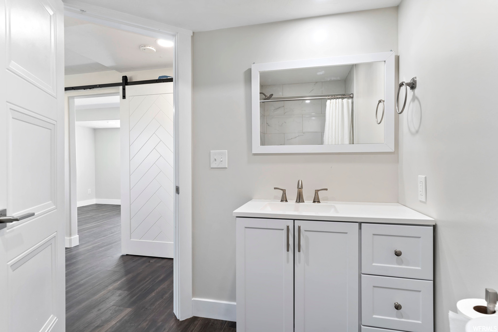 Bathroom with wood-type flooring, mirror, and vanity
