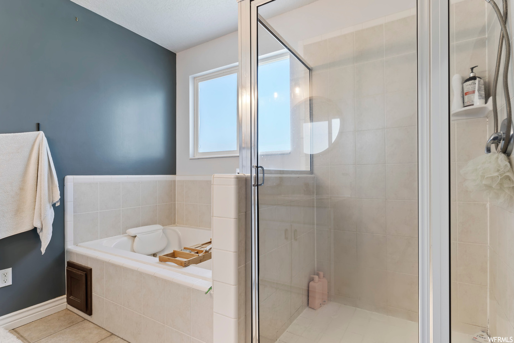 Bathroom featuring separate shower and tub and light tile floors