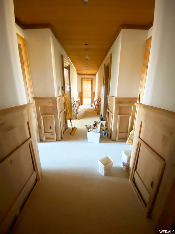 Corridor featuring carpet floors and ornamental molding