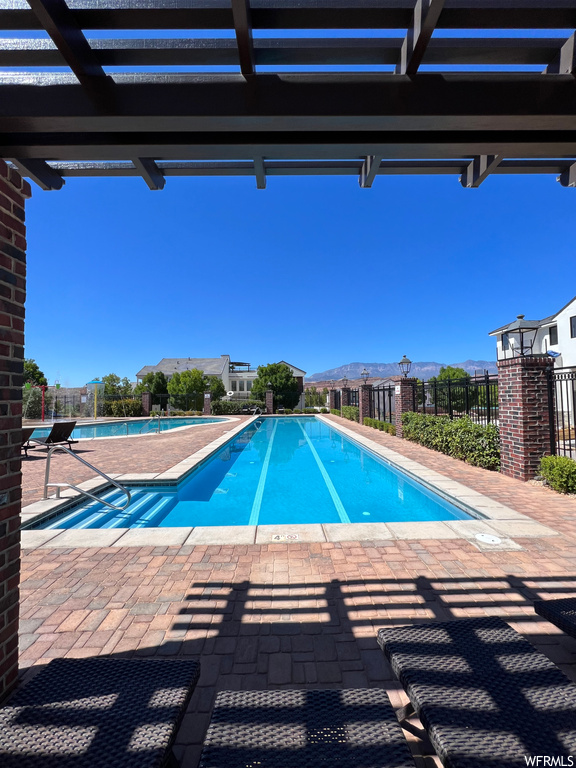 View of swimming pool featuring a patio and a pergola