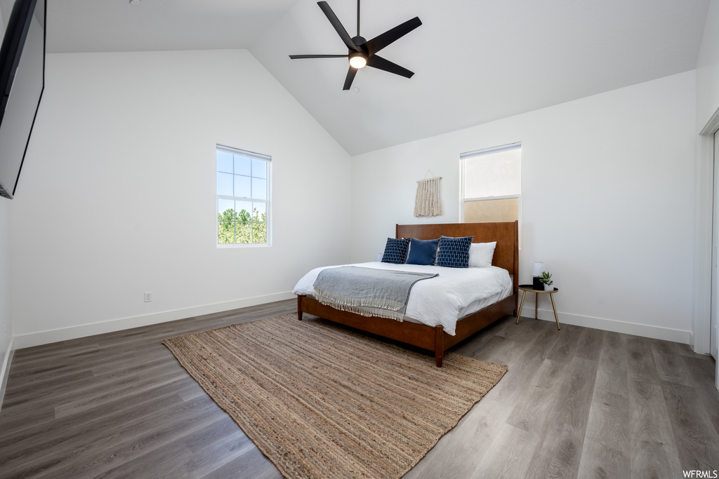 Bedroom featuring a high ceiling, lofted ceiling, and light hardwood floors