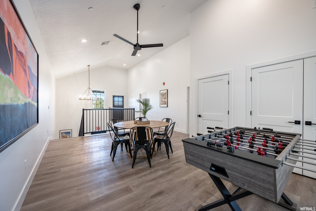 Game room featuring vaulted ceiling, light hardwood floors, and a high ceiling