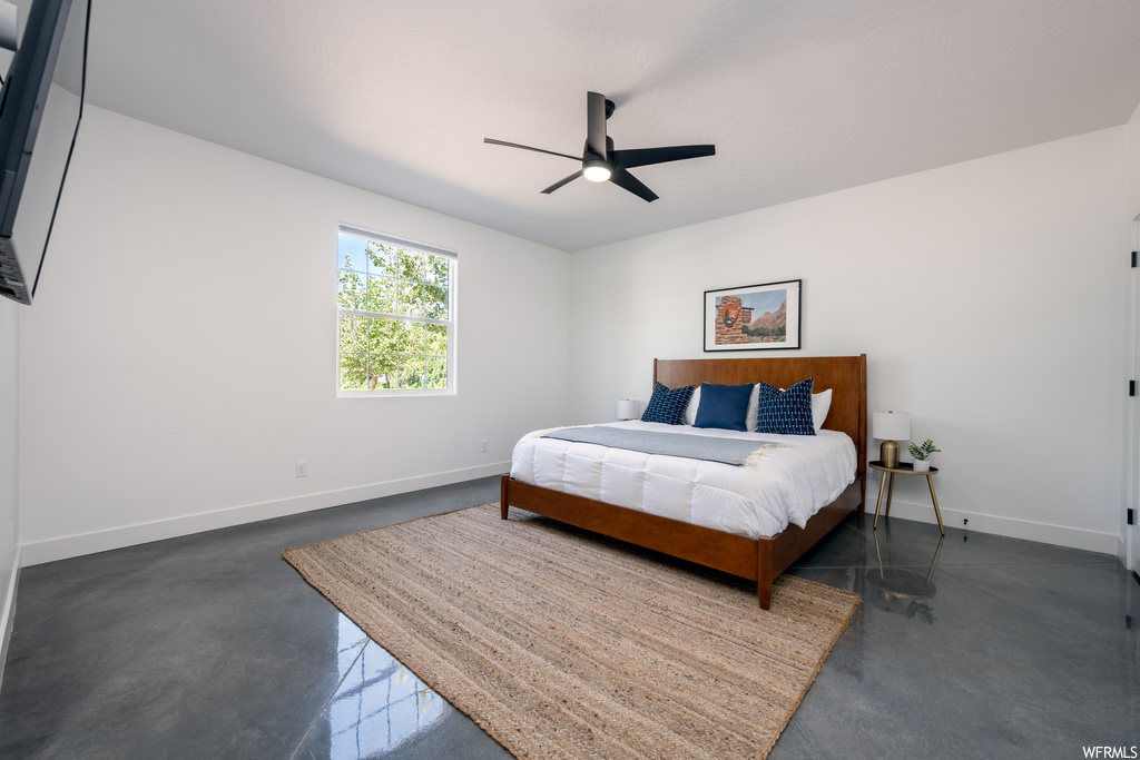Bedroom with concrete flooring and ceiling fan
