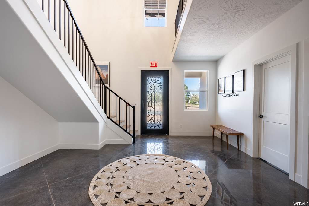 Entryway with a textured ceiling and dark tile flooring