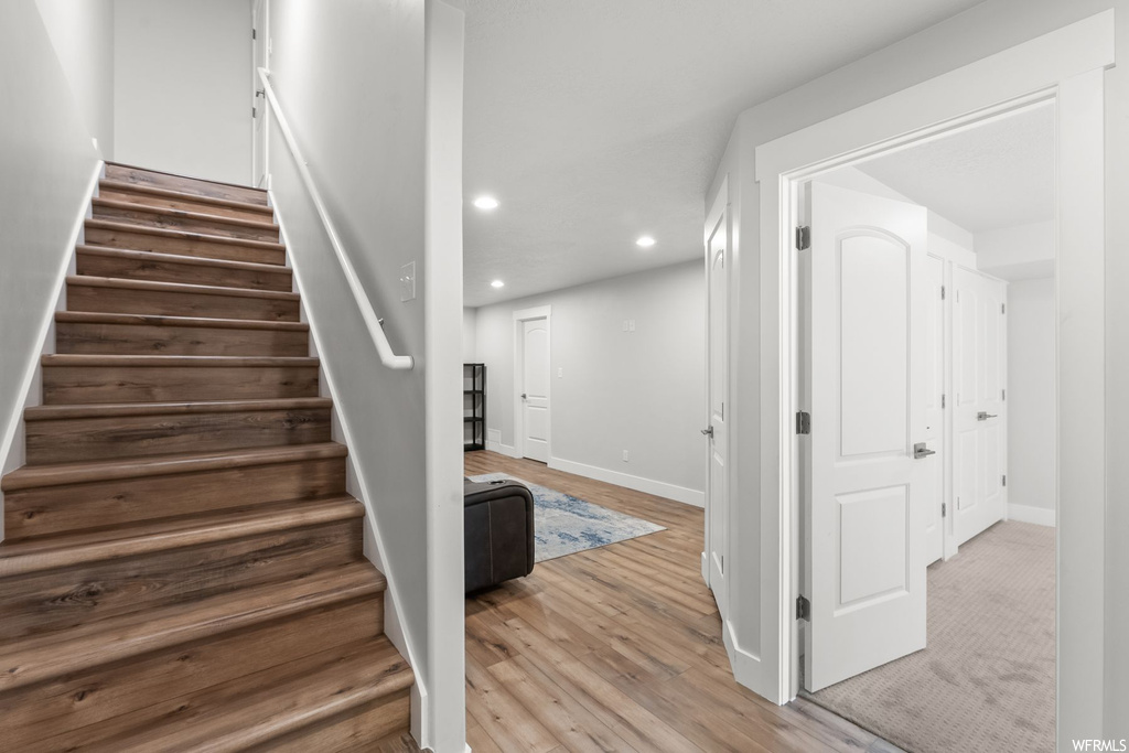 Stairs featuring light hardwood floors