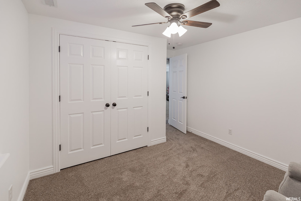 Carpeted bedroom with ceiling fan