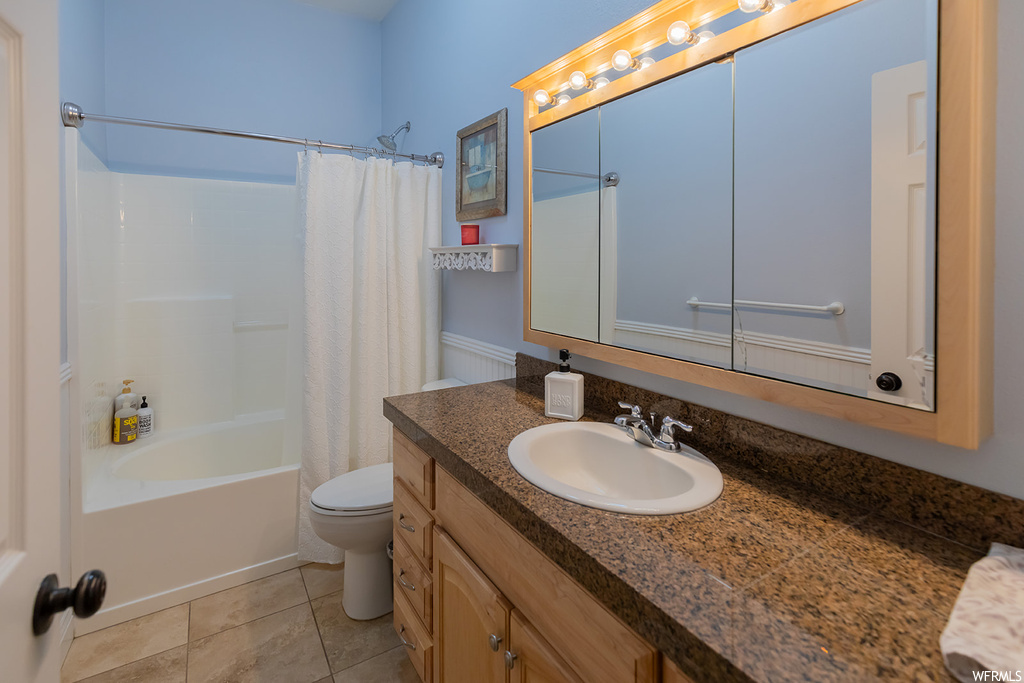 Full bathroom featuring shower / bath combo, mirror, large vanity, and light tile floors