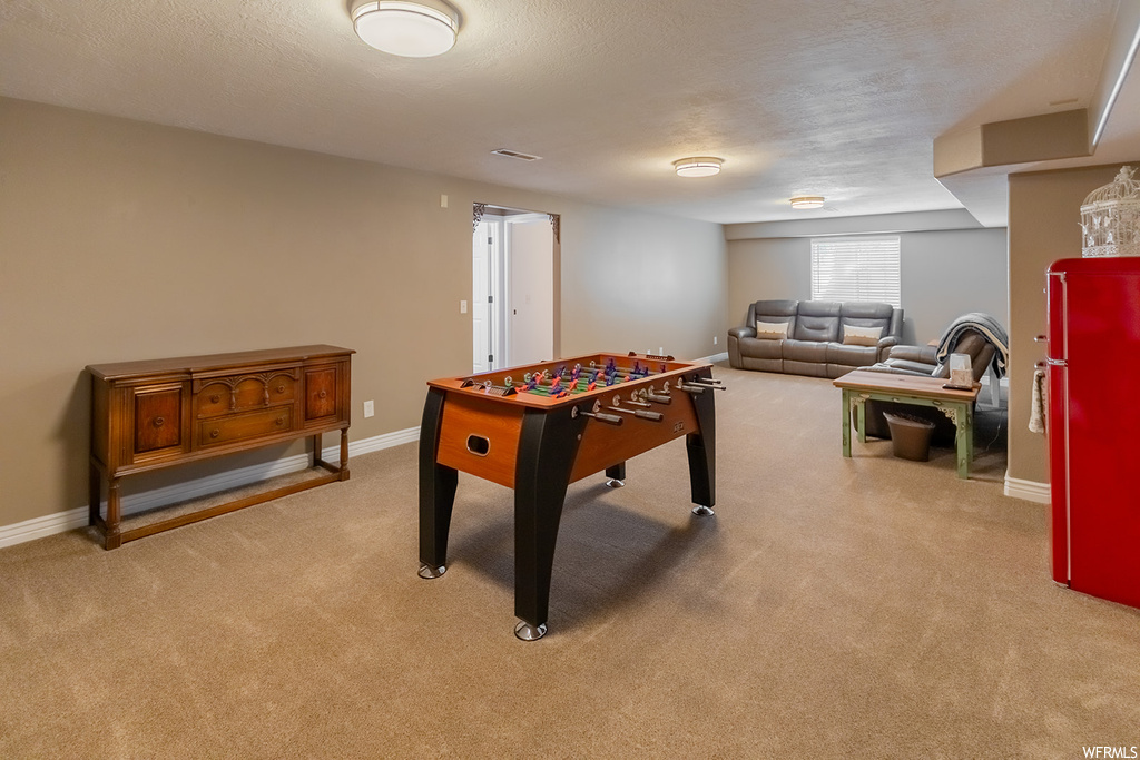 Playroom featuring light carpet and a textured ceiling