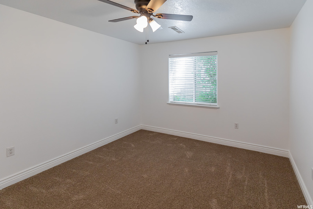 Empty room with carpet floors and ceiling fan