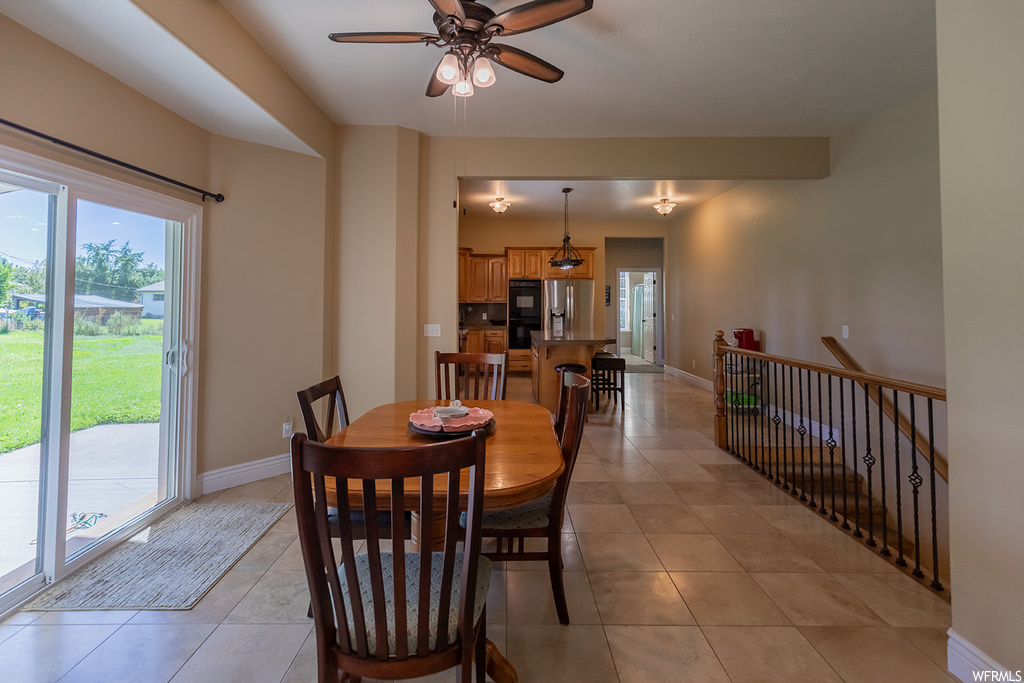 Tiled dining space featuring ceiling fan