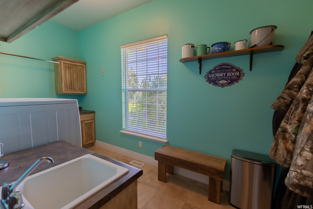 Bathroom featuring a bath to relax in and light tile flooring