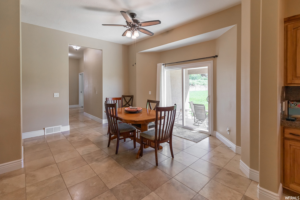 Dining space with ceiling fan and light tile floors