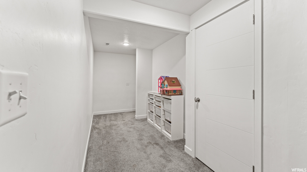 Corridor featuring light carpet
