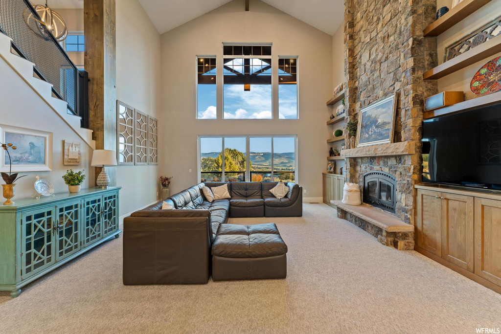 Carpeted living room with a fireplace, a high ceiling, and vaulted ceiling