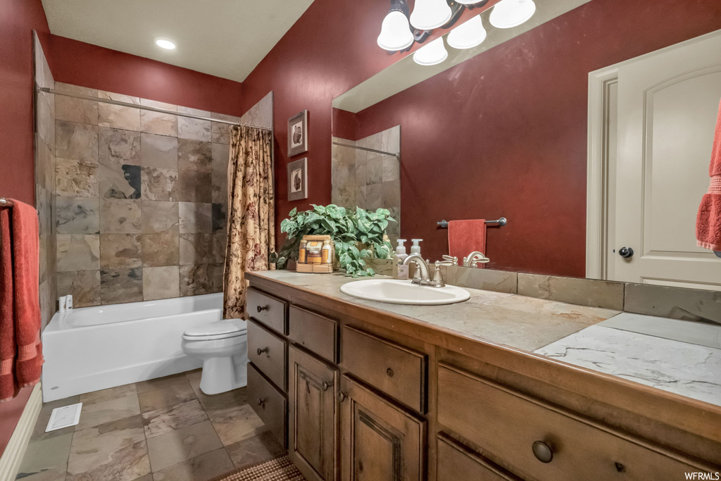 Full bathroom featuring shower / tub combo, vanity with extensive cabinet space, tile floors, and mirror