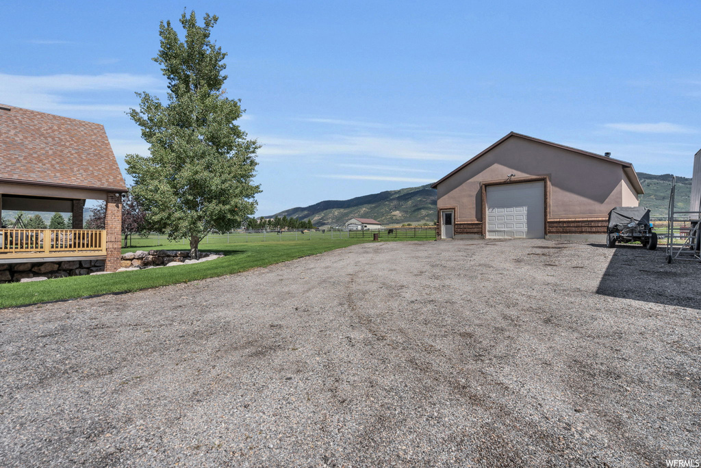 Exterior space featuring a mountain view, garage, and a front lawn