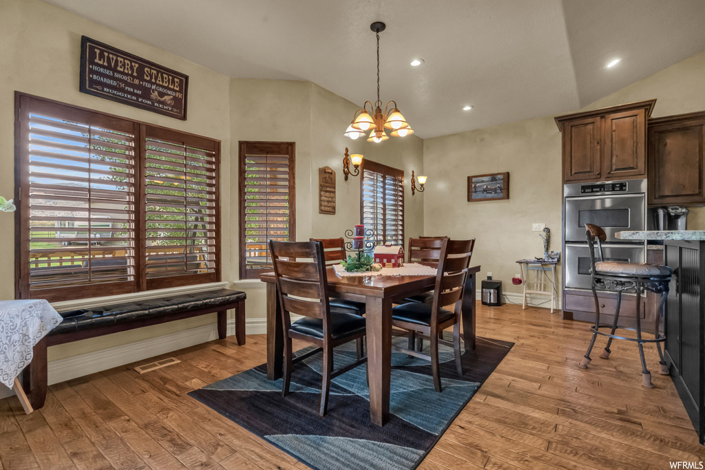 Dining room with vaulted ceiling and light hardwood flooring