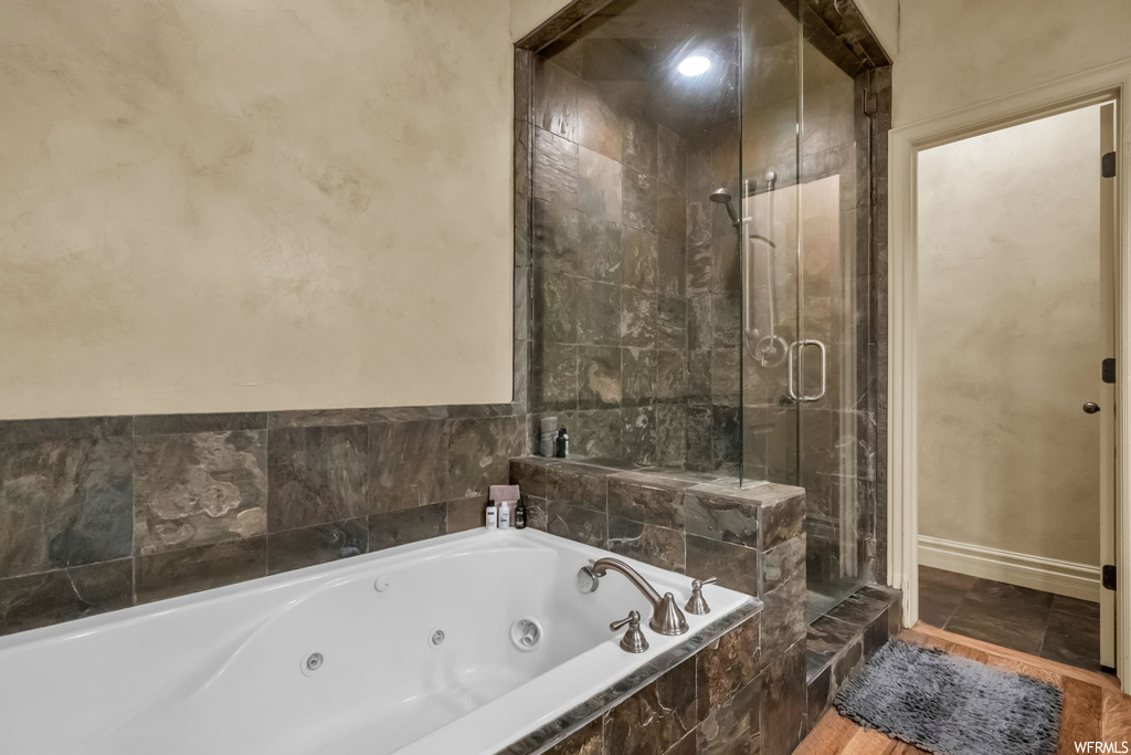 Bathroom with dark tile floors and shower with separate bathtub