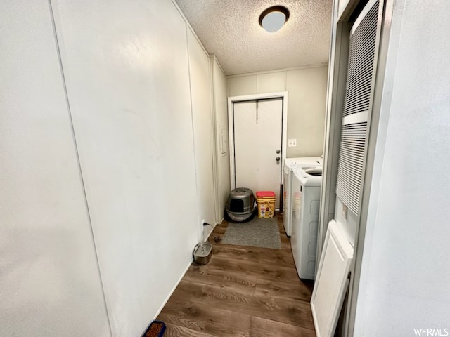 Clothes washing area with a textured ceiling and dark hardwood flooring