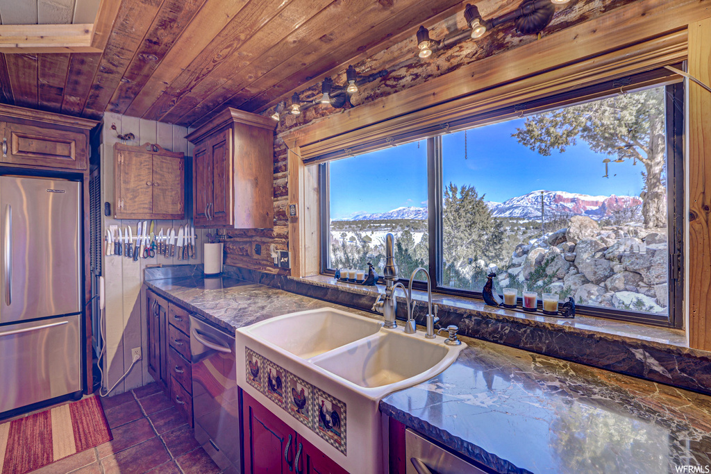 Kitchen featuring wood ceiling, sink, dark tile floors, a mountain view, and stainless steel refrigerator