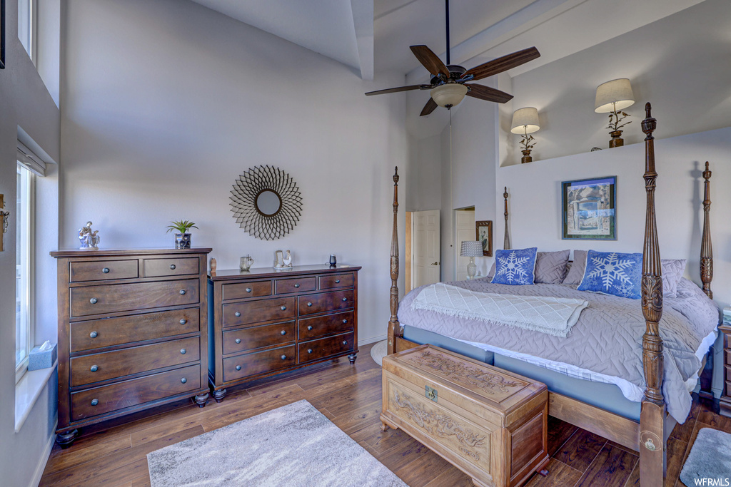 Bedroom featuring dark wood-type flooring, ceiling fan, and a high ceiling