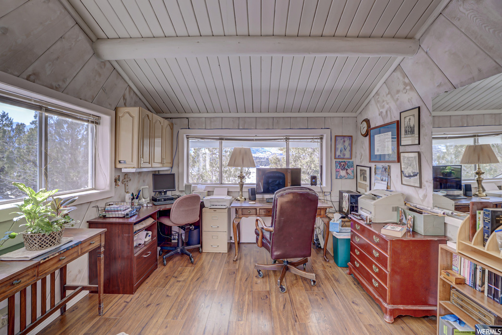 Office space featuring vaulted ceiling with beams and light hardwood / wood-style flooring