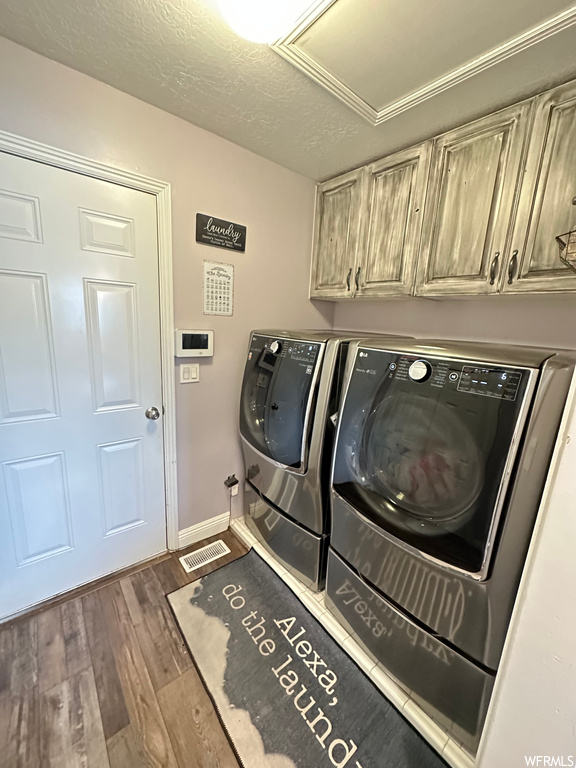 Laundry room with hardwood floors and washing machine and dryer