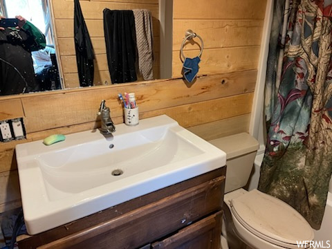 Bathroom featuring wood walls, vanity, and mirror