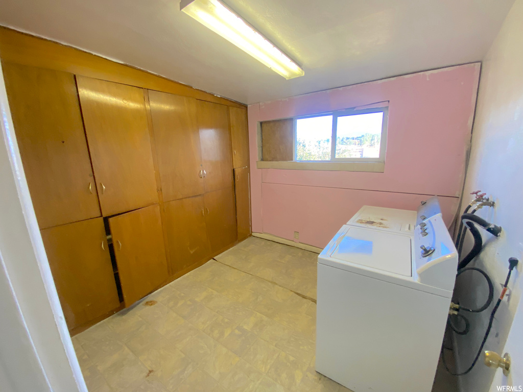 Laundry area featuring washer / clothes dryer and light tile flooring