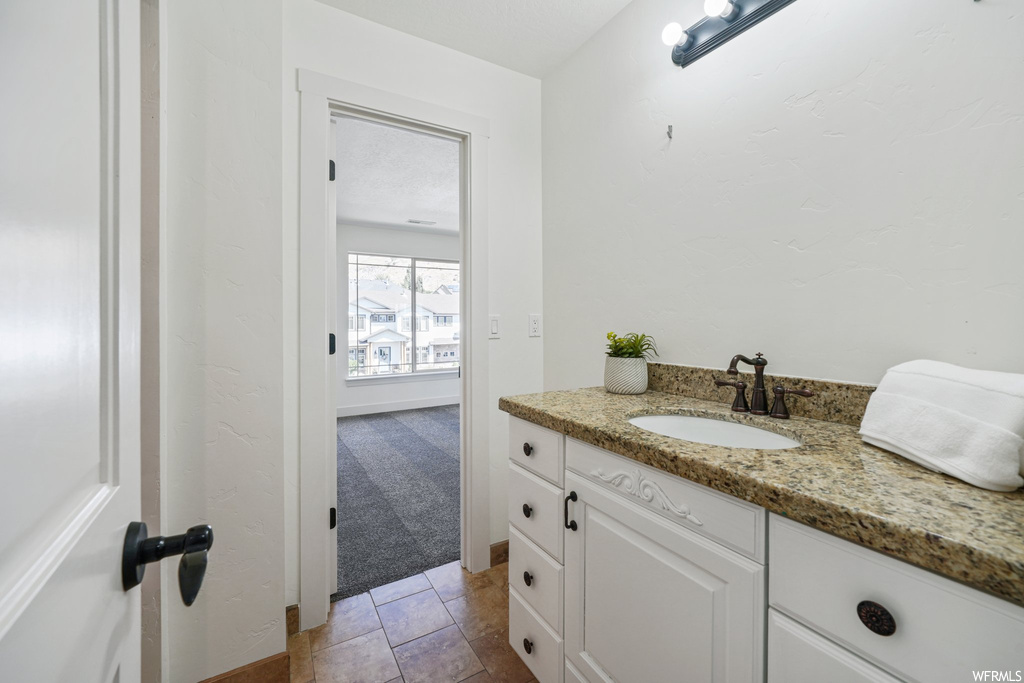 Bathroom with vanity and light tile flooring
