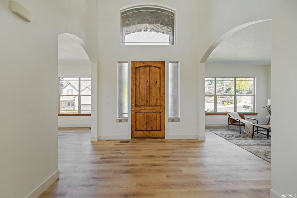 Entryway with a high ceiling and light hardwood flooring