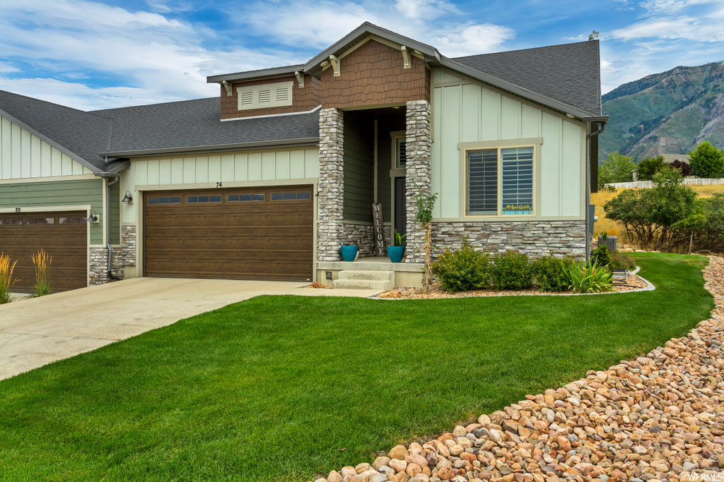 Craftsman inspired home featuring a front yard and garage