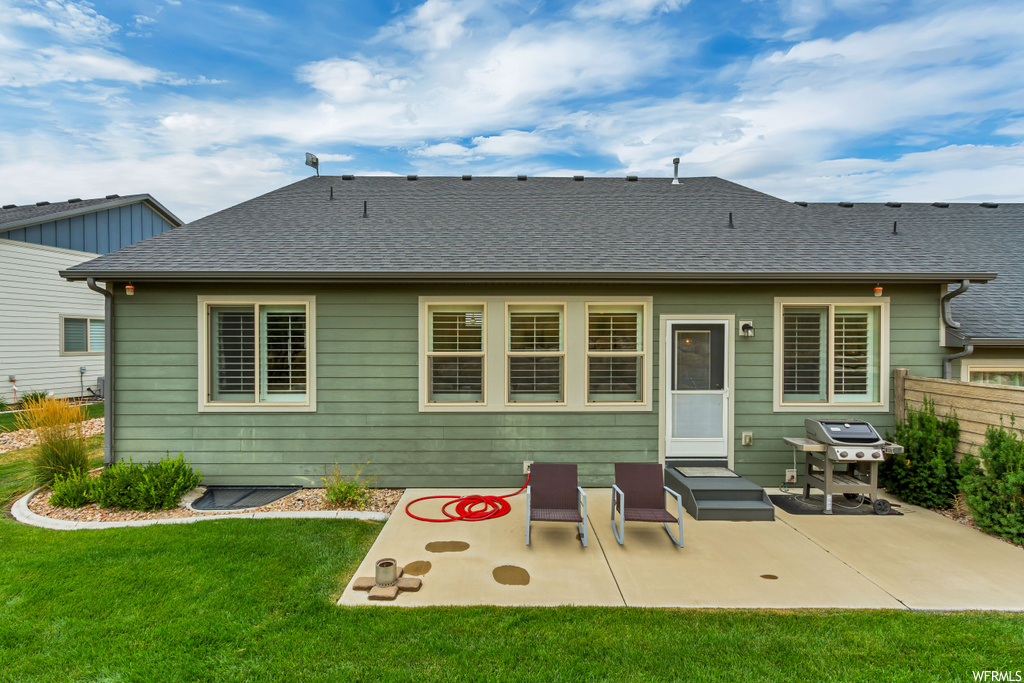 Back of property featuring a yard and a patio area