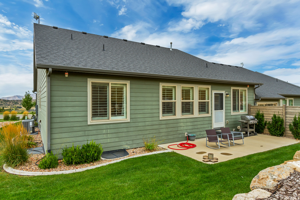 Back of property featuring a yard and a patio area