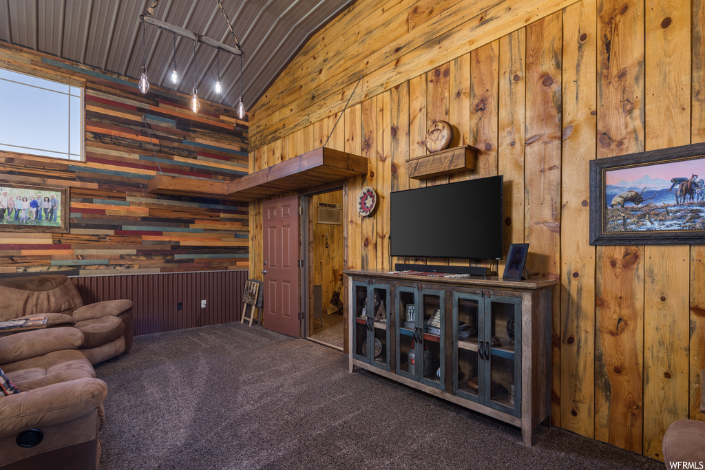 Carpeted living room with wood walls, an AC wall unit, and vaulted ceiling